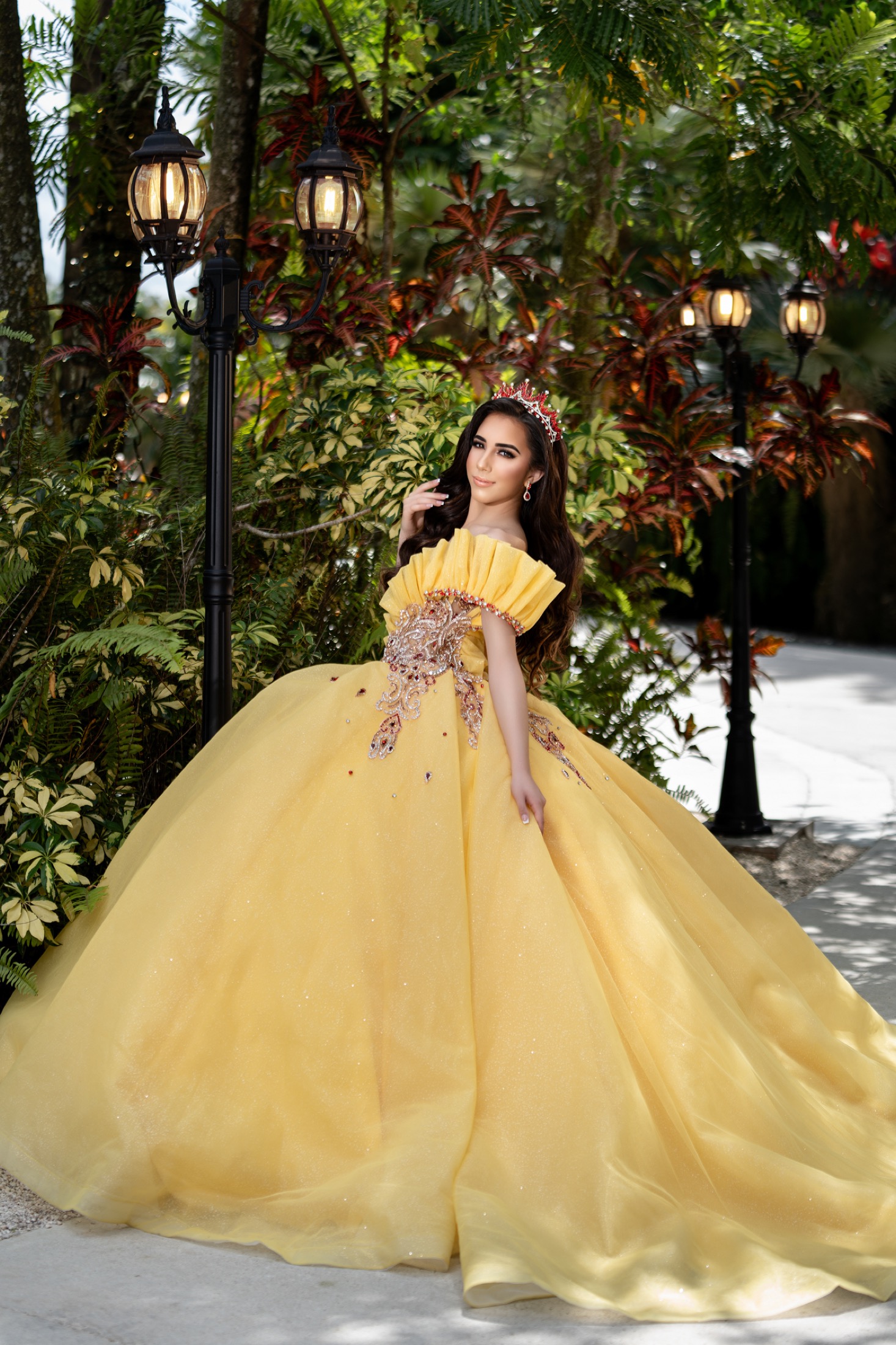 Quinceañera in a yellow gown in a garden setting